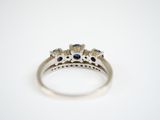 a close up of a diamond and sapphire ring on a white surface