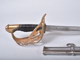 a sword that is laying on the ground next to a piece of metal