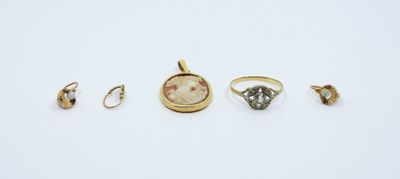 a group of five rings and a pendant on a white surface