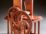 une photo représentant une maquette en bois d'une machine à filer posée sur une table