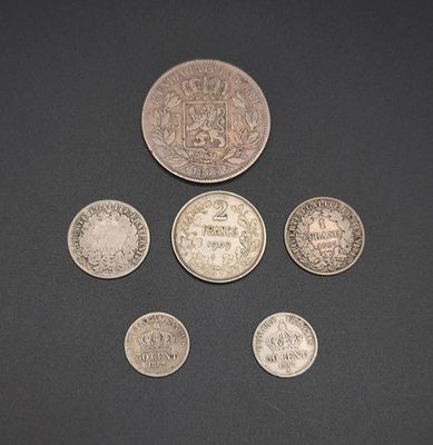 six different british coins on a black surface