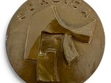 une médaille d'or sur laquelle figure le portrait d'un homme
