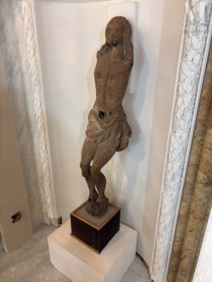 une statue représentant un homme debout sur un socle dans une pièce