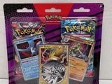 a close up of two pokemon cards on a white surface