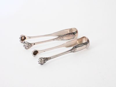 three silver spoons sitting on top of each other on a white surface