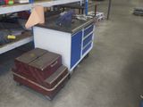 Plusieurs bagages sont empilés sur un chariot dans un entrepôt