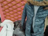 une chaise rose sur laquelle est posé un blouson bleu