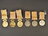 a group of medals and medals on display on a black surface