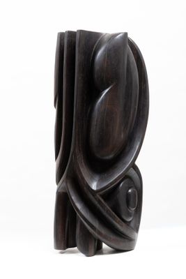 a wooden sculpture that is sitting on a white surface