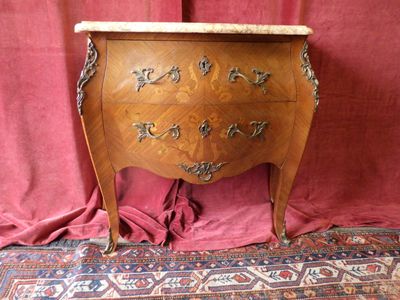 une commode en bois avec un plateau en marbre, posée sur un tapis