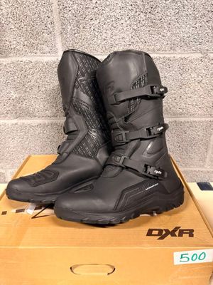 pair of black motorcycle boots sitting on top of a cardboard box