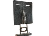 une photo d'une sculpture métallique représentant le visage d'un homme, posée sur un socle