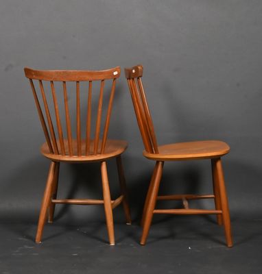 deux chaises en bois placées l'une à côté de l'autre sur un fond gris