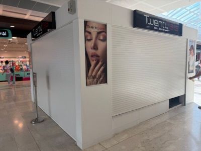 a woman that is walking through a mall with a cell phone