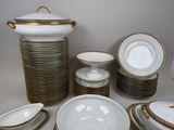 a lot of white and gold plates and bowls on the table