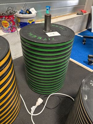 une grande pile de tuyaux noirs et verts posée par terre