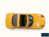 a yellow toy car that is sitting on a white surface