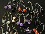 de nombreuses paires de boucles d'oreilles posées sur une surface noire