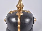 an old helmet with a gold spiked top on a white surface