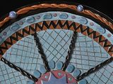 a picture of a decorative plate with chains and beads on it