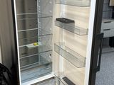 an empty refrigerator with its door open on the floor
