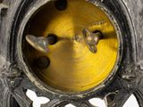 a close up of a metal clock with a yellow face