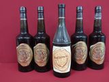 six bottles of beer are lined up on a red surface