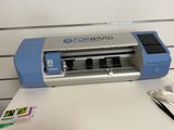 une machine bleue et argentée posée sur une table blanche