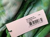 the label is on the back of a green tie dyed shirt