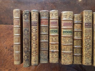 several old books are lined up in a row on a table