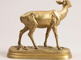 statue of a golden deer on a stand on a white background