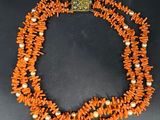 an image of a necklace made of orange coral beads and pearls
