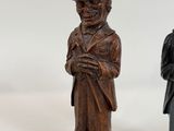 two wooden figurines of a man and a woman