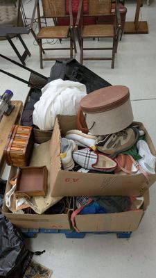 une boîte remplie d'objets hétéroclites posée sur le sol