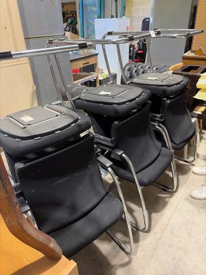 three black chairs in the room with luggage on them