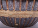 a close up of a vase on a white surface