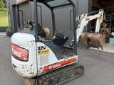 an image of a small excavator parked in front of a building
