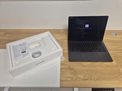 a laptop computer sitting on top of a desk next to a box