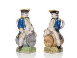 paire de figurines en céramique représentant un homme et une femme assis sur un tonneau