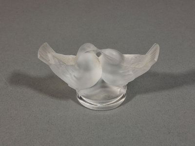 une sculpture en verre représentant deux oiseaux perchés l'un sur l'autre