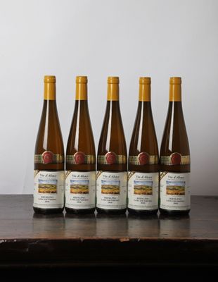six bouteilles de vin sont alignées sur une table en bois