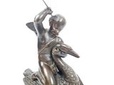 a bronze statue of a boy on a turtle with a sword