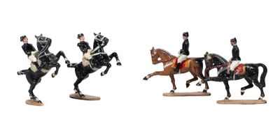 three figurines of men riding horses and one on a horse