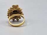 an image of a gold ring with a blue stone in the center