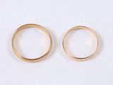 two gold rings sitting next to each other on a white surface