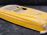 a yellow toy car that is sitting on a black surface