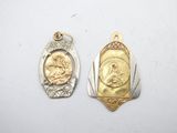 two gold and silver pendants with a picture of jesus