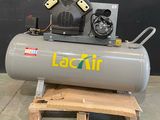 un compresseur d'air gris posé sur une palette en bois