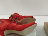 pair of red high heeled shoes sitting on top of a white surface