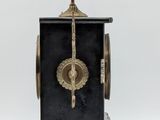 a black and gold clock with a bird on top
